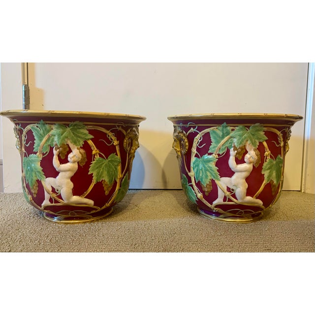A pair of stunning planters in the neoclassical style. Red background featuring a vibrant majolica style green grapevine...