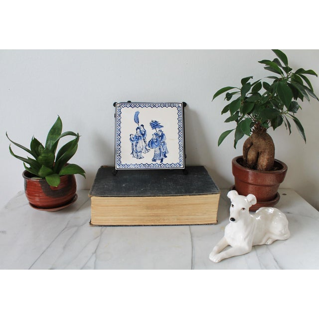 Vintage Chinese porcelain tile on footed metal base. Could serve as a plant stand or a place to set your coffee down....