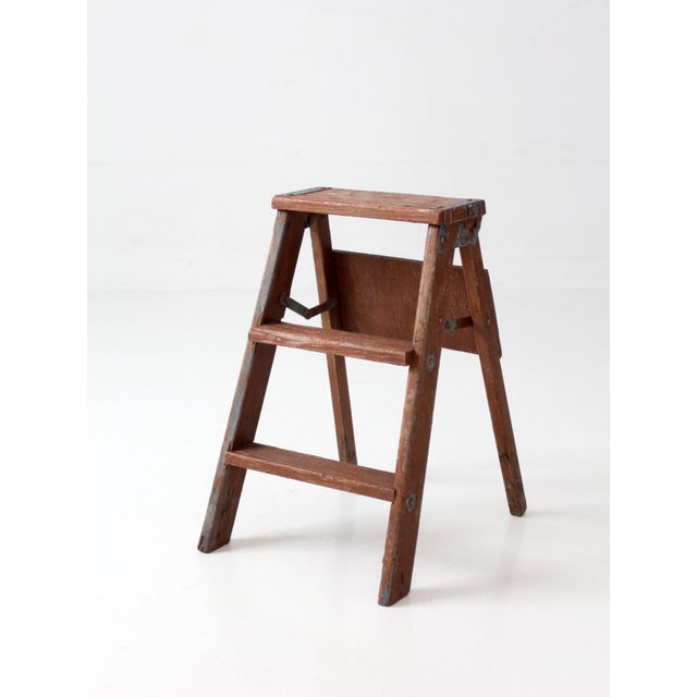 Antique early 20th century folding wooden step ladder with compact proportions, a beautifully aged wood finish, and a...