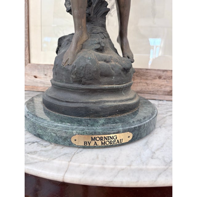 An exceptional antique bronze sculpture titled “Morning,” signed A. Moreau, depicting an elegant female figure surrounded...