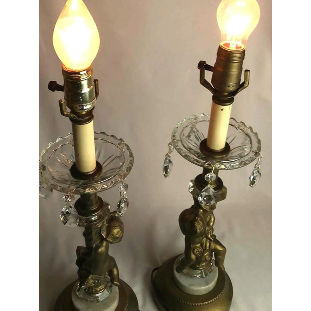 Very beautiful pair of crystal and bronze and marble cherub lamps. They both work. one seems to have been sliced together...