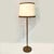 Luxurious pair of 1960's floor lamps in mid brown leather with large parchment and leather shades creating a warm...