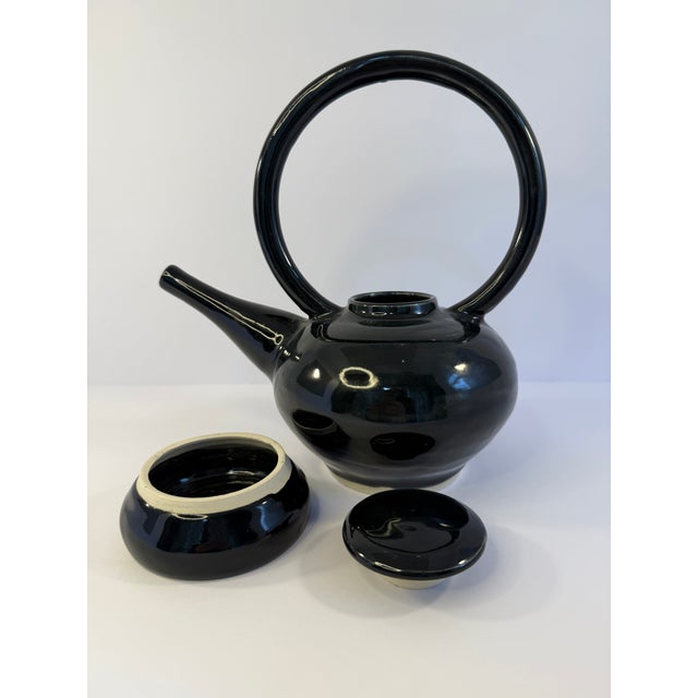 Fabulous handcrafted pottery teapot with top and small pedestal for display. With a sweeping round handle the modern...