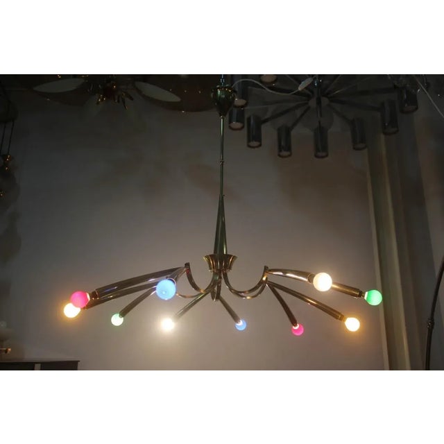 - Chandelier from the 1950s - Made of brass - Trumpet shaped arms - Original colored bulbs I have official proof of...
