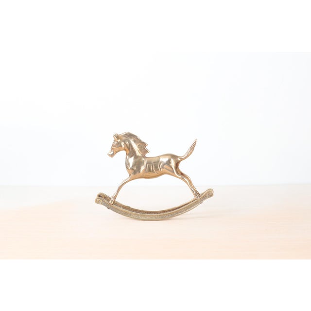 Vintage solid brass rocking horse figurine with a sleek, sculptural silhouette and gently arched double base. The polished...