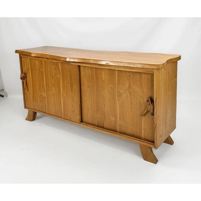 Rustic live edge sideboard is crafted from solid wood, showcasing natural grain patterns and a warm, earthy tone....