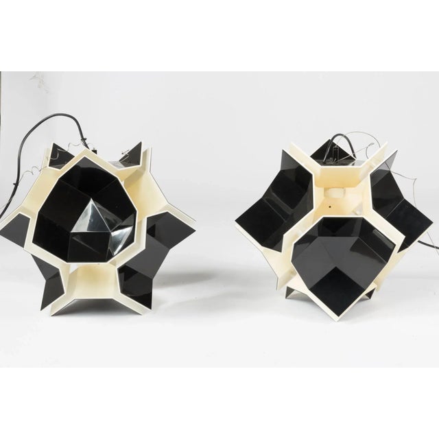 A pair of suspension light by DARK, Belgium. Circa early 21st century. Black and off white plastic with single E27 socket...