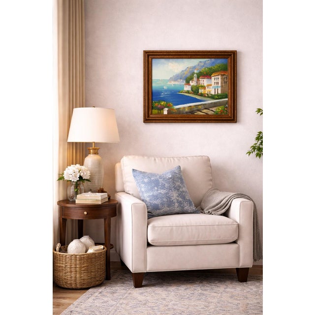 This charming oil on canvas painting depicts a sunlit Mediterranean coastal village overlooking a tranquil blue sea....