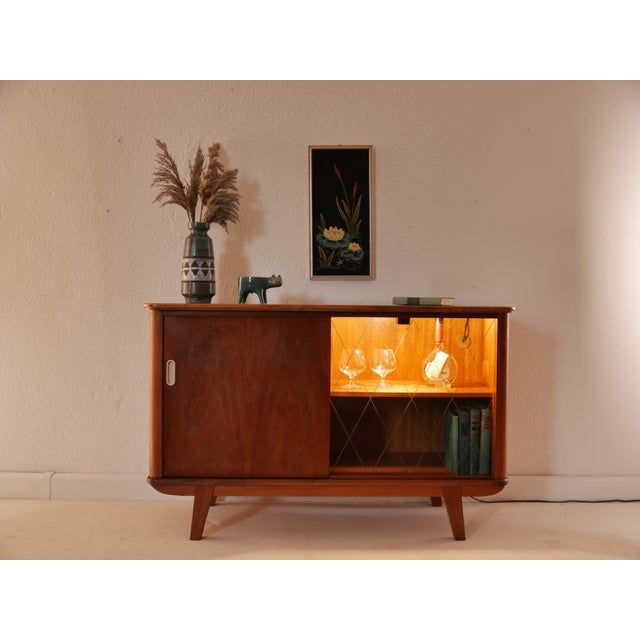 An original vintage sideboard from the 1960s in a timeless mid-century design. Particularly striking are the harmoniously...