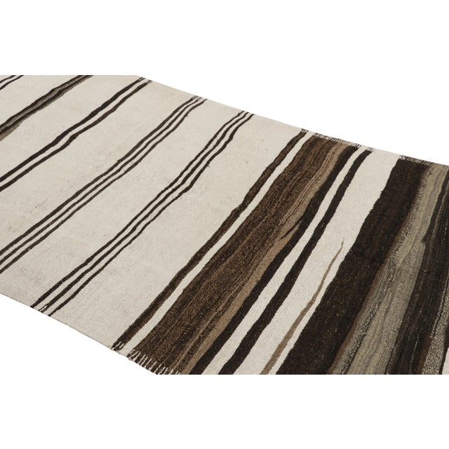 Handwoven in a wool flatweave originating from Turkey circa 1950-1960, this 5x11 vintage Kilim runner rug connotes a mid-...