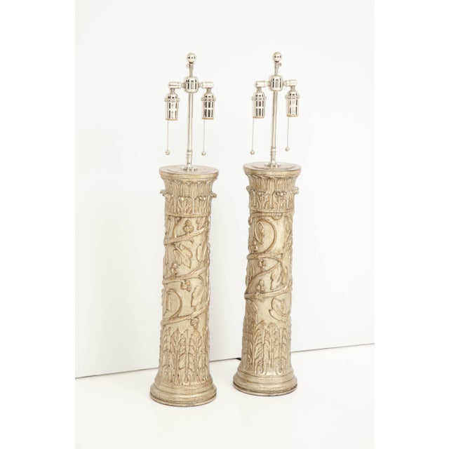 Pair of column lamps by James Mont. The lamps have a beautiful decorative design with a glazed silver leaf finish. They...
