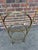 Vintage brass tone iron display shelf with four glass shelves. The frame features scroll details at the top and feet,...
