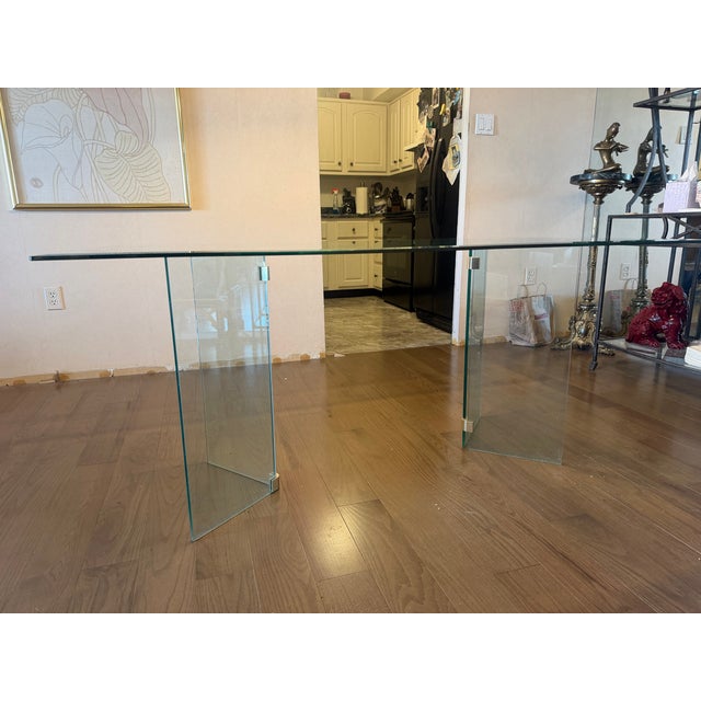 1980’s Leon Rosen for Pace rectangular glass dining table with brass. The large, tapered table top is supported by two...