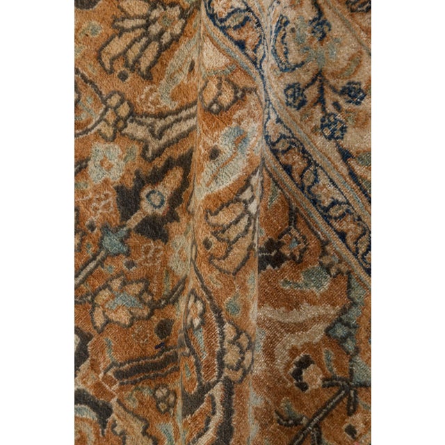 An early 20th century Mashad Persian rug rose field with an allover stylized floral trellis within a palmette vinery...