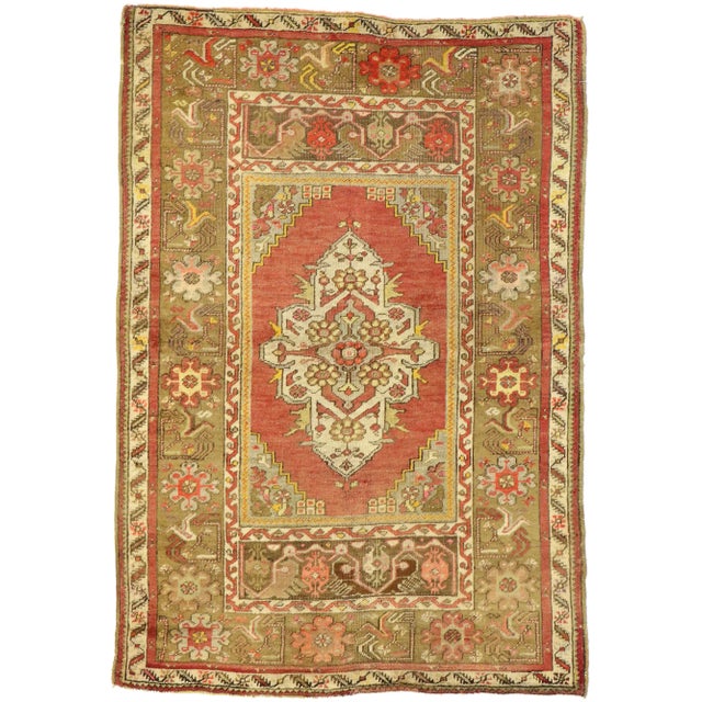 This hand knotted wool vintage Turkish Oushak rug features a cross-like centre medallion in an abrashed scarlet red field....