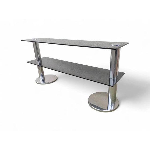 Italian console table in smoked glass and steel, 1970s. Chromed steel frame, with two cylindrical columns and two smoked...