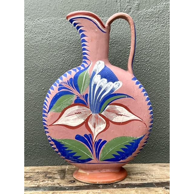 This vibrant vintage Mexican pitcher is a masterful display of traditional folk art and artisanal ceramic craftsmanship....