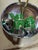 Six green and silver MCM aluminum napkin rings stamped made in Hong Kong.