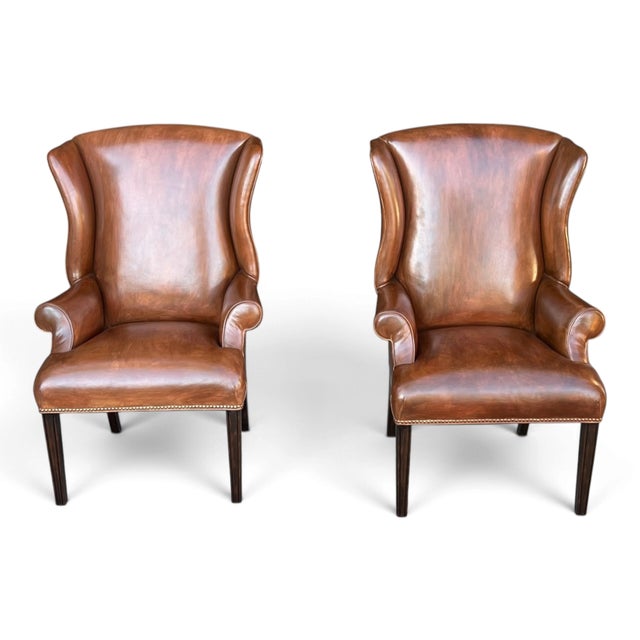 This vintage pair of cognac leather wingback chairs combines classic comfort with Louis XVI–inspired detailing. Tall...