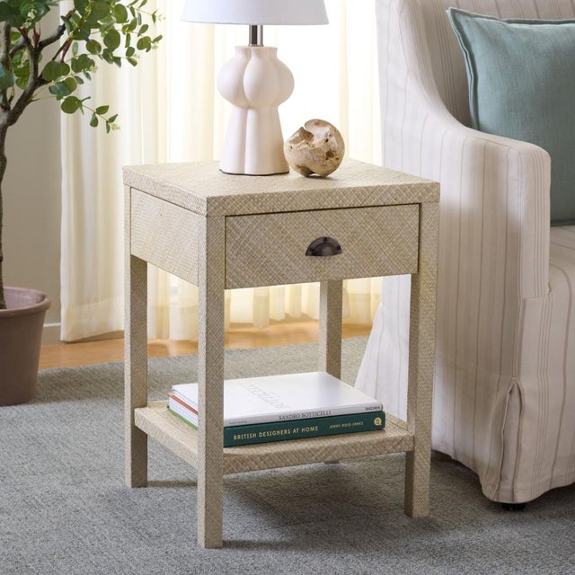 Introduce sophistication and functionality into your living space with the Apis Raffia 1 Drawer 1 Shelf Accent Table in...