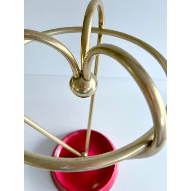 Vintage umbrella stand, 1950s, gold anodized aluminum arches joined in the middle with a brass sphere and a bright red...