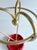 Vintage umbrella stand, 1950s, gold anodized aluminum arches joined in the middle with a brass sphere and a bright red...