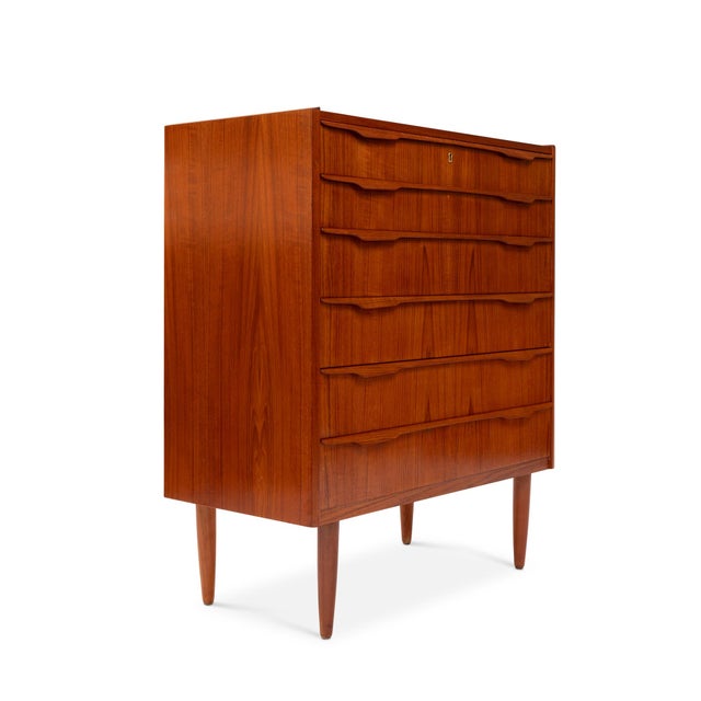 This striking Danish Mid-Century teak tallboy dresser, crafted in the 1960s, is a beautiful example of timeless...