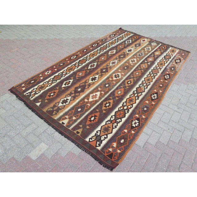 This beautiful, traditional vintage, flatweaved Turkish kilim rug is approximately 60 years old. It is handmade of very...