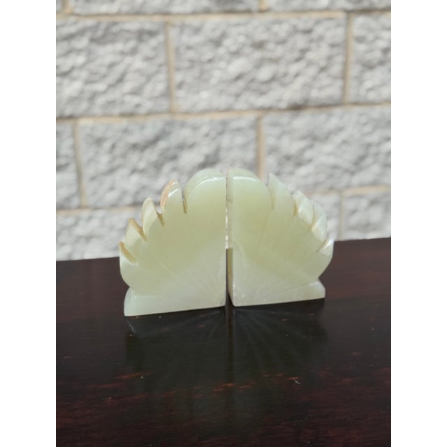 Pair of carved green onyx bookends with a stepped geometric design and softly translucent stone. Natural variation...