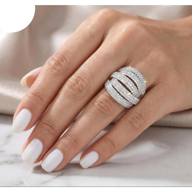 This 18K white gold dome band ring features a unique design adorned with numerous brilliant round diamonds, totaling 2.4...