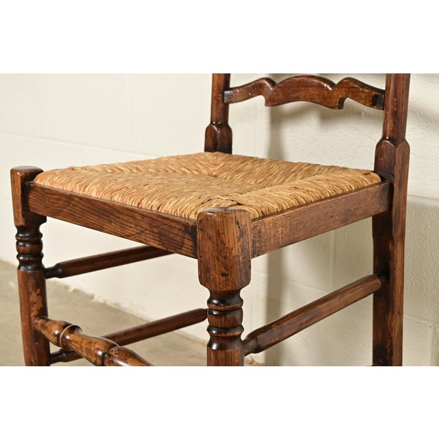 Baker Furniture Style English Country Rustic Carved Solid Oak Ladder Back Dining Chairs With Rush Seats, Pair For Sale - Image 9 of 13