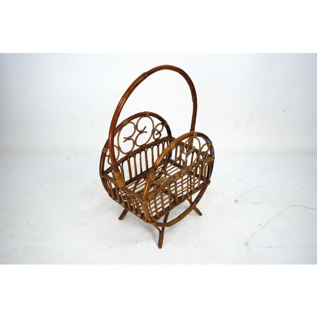 Elegant Italian magazine rack crafted from bamboo and woven rattan, dating to the 1950s. This charming mid-century piece...