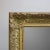 An antique and large Continental giltwood wall mirror offers frame with scroll foliate and stylized fleur-de-lis...