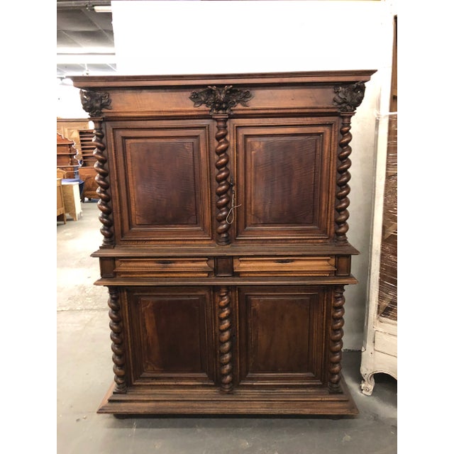 French Louis XIII buffet a deux corps in walnut with two doors atop two drawers and two bottom doors. Carved barley twist...