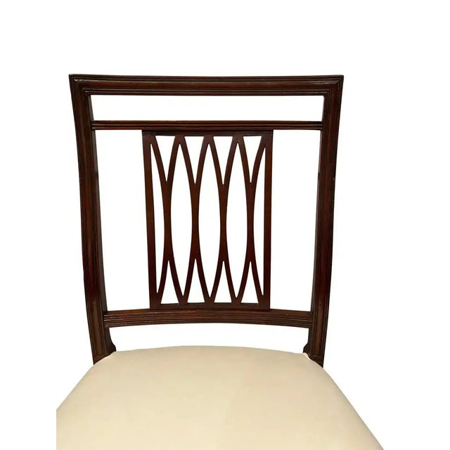 Consisting of eight side chairs, each with a rectangular back with trellis splats, upholstered seats raised on square...