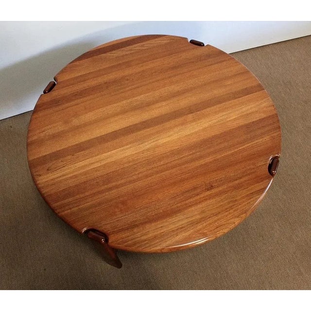 Circular coffee table by designer Niels Bach in solid teak, consisting of a thick top with a rounded edge. The top has...