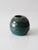 This vintage studio pottery vase features a flowing, organic form with a richly textured surface. The deep teal glossy...