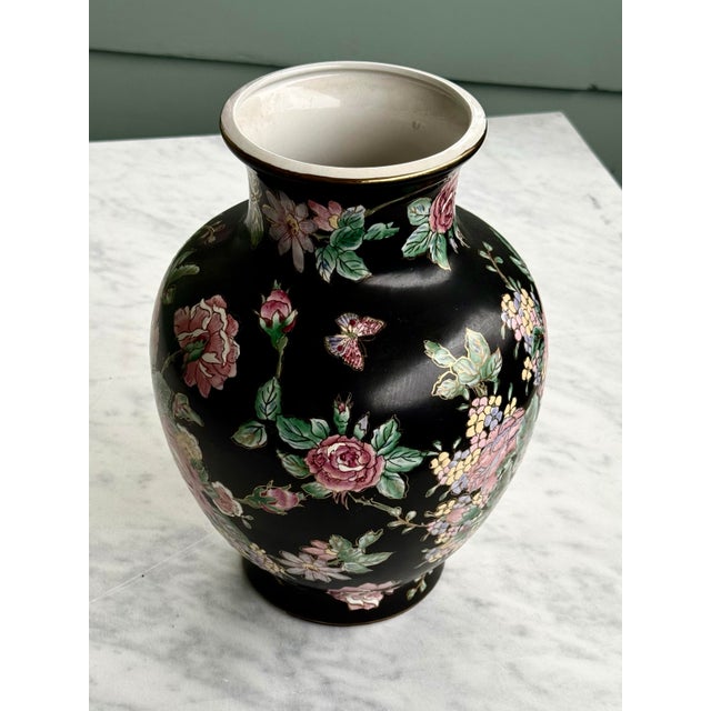 Vintage chinese porcelain vase featuring a famille noire style, characterized by a black ground decorated with colorful...