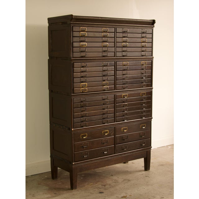 This early 20th century stacking flat file cabinet is built of quartersawn oak in its original dark finish, with 42...