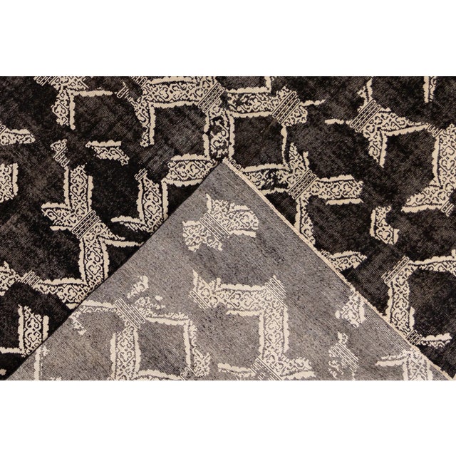 Beautiful Mid-Century-Style hand-knotted wool rug with a black field. This Vintage has ivory accents in a gorgeous overall...