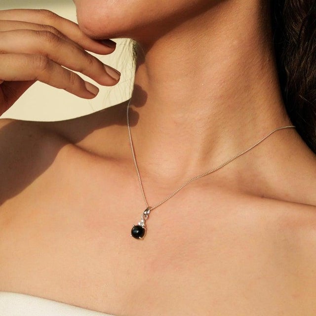 This pendant is crafted in 925 sterling silver and features a captivating 3.95 carat Black Star gemstone measuring 9 mm....