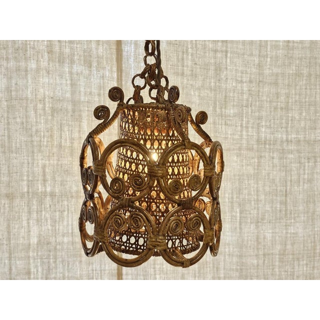 A charming Italian rattan pendant lamp dating from the 1960s, handcrafted in woven cane and wicker with an exuberant...