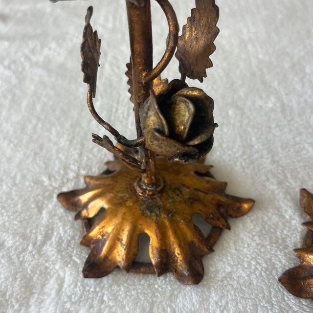 Pair of vintage Italian candlesticks with rose design. Gold gilded and has patina.