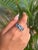Crafted in 925 Sterling Silver, this elegant ring features three oval-cut Blue Topaz gemstones, radiating a serene ocean-...