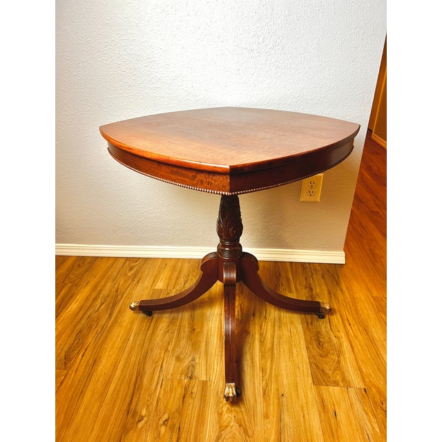 Regency Revival mahogany pedestal table, American, circa 1910, featuring a distinctive shield-shaped fixed top with fine...