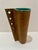 Sculptural vintage ceramic vase with tall cylindrical form, warm brown glaze, and a vertical row of pierced openings with...