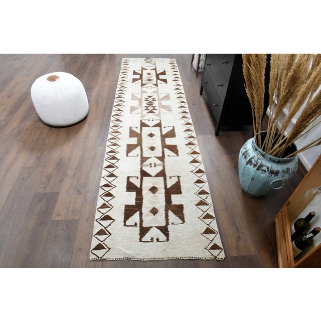 Vintage Hand-Knotted beige brown runner rug is a semi-antique vintage runner rug. The '70s Eastern region of Anatolia's...