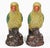 Pair of colorful Chinese antique yellow and green feathered parrots with orange beaks standing on a brown tree stump.