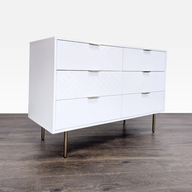 This Pottery Barn dresser features a clean white finish, modern geometric detailing, and six spacious drawers for plenty...