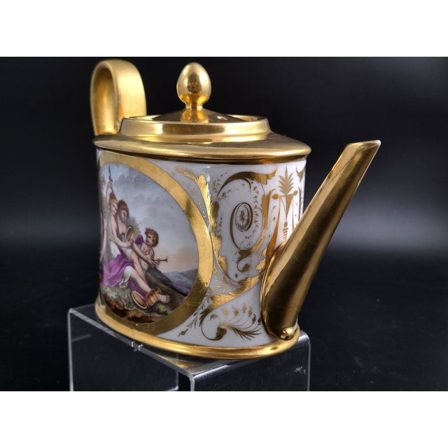An exceptional French porcelain oval teapot, of the théière « Ovale » or « Bielle » form, hand-painted and gilded at the...